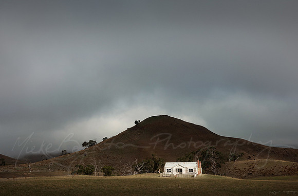 A little house and a stormy sky in Tasmania Australia by photographer Mieke Boynton